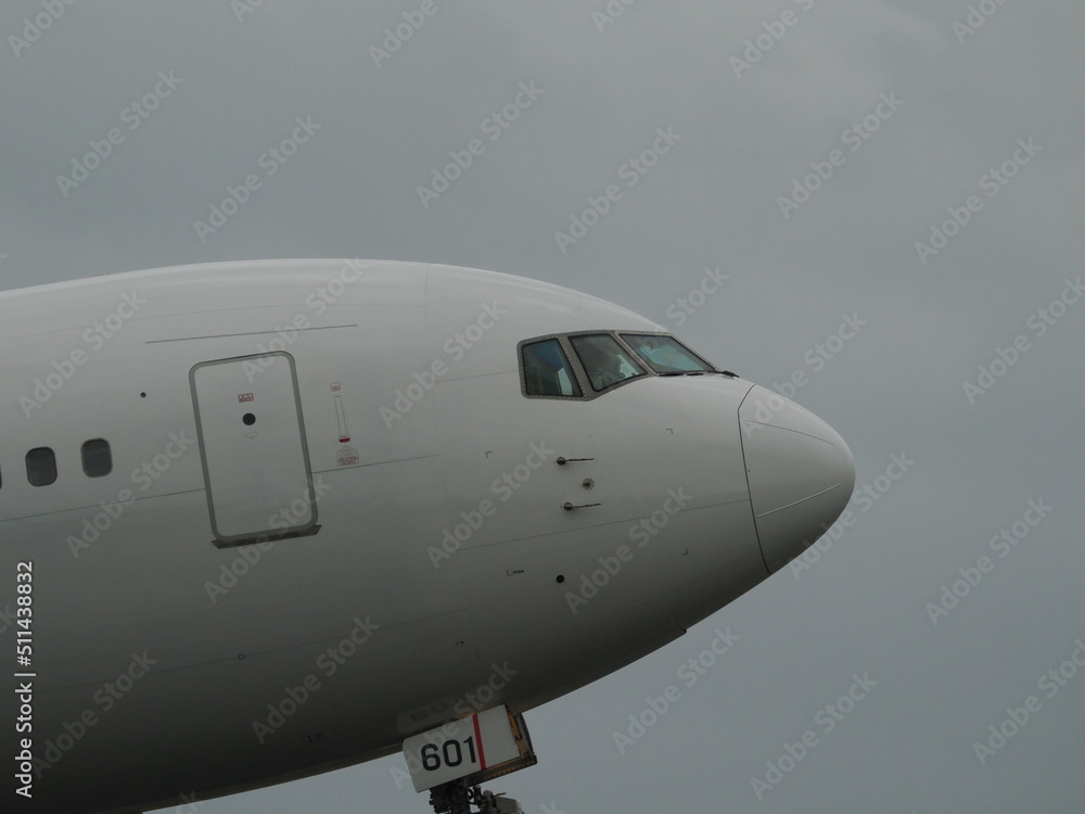 曇り空の下、離陸していく旅客機の機首