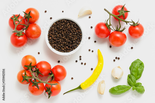 Cherry tomatoes, green basil leaves and chili pepper on white background.