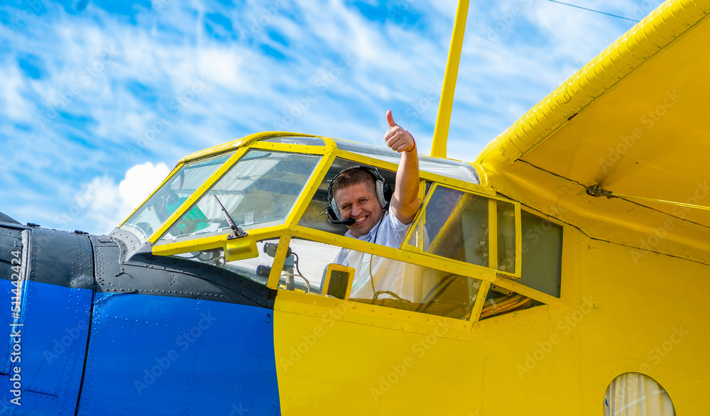 Joyful Caucasian young airline pilot smiling and showing thumbs up from ...