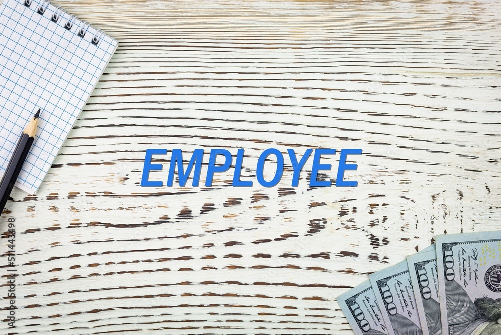 Naklejka premium EMPLOYEE - word (text) and dollars on a white wooden table, notebook, notepad. Business concept: buying, selling, commerce (copy space).