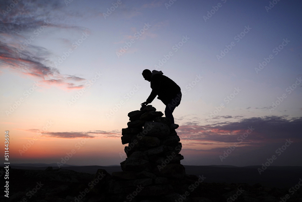 silhouette of a person on the top of raks