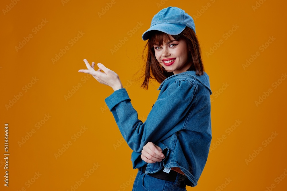 Positive young woman denim clothing fashion posing cap color background unaltered Positive young woman denim clothing fashion posing cap color background unaltered