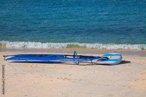 windsurf board and sail on the beach sand