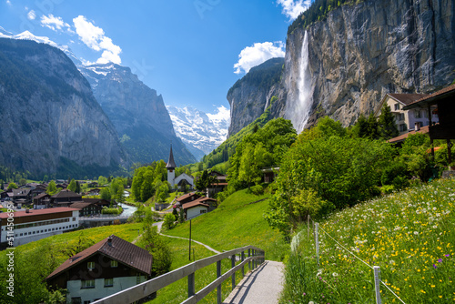 amazing alpine landscape in Lauterbrunnen village with church and waterfall in Switzerland photo