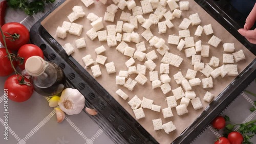 making caesar salad croutons - sliced toast bread on baking tray photo