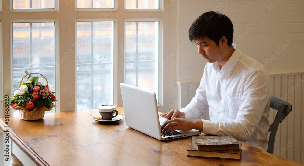 Fototapeta premium Focused handsome businessman working with computer at bright office.