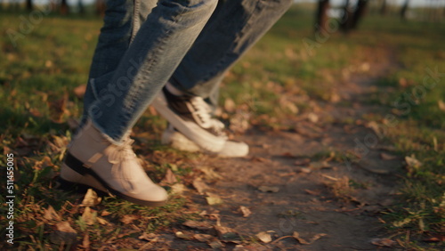 Parents kid leg walking autumn park field together closeup. Outdoor leisure time
