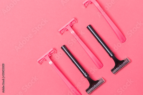 Female Hygiene Concepts. Closeup Image of Five Colorful Pink and Black Disposable Razors Shavers Placed Together Over Trendy Pink Coral Background.