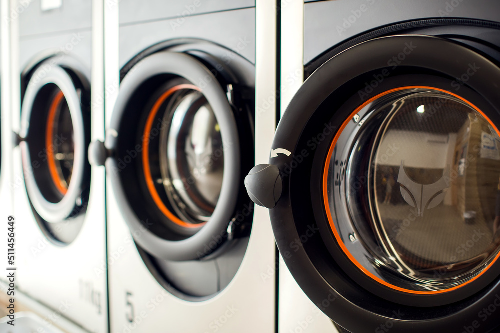 Row of industrial laundry machines in laundromat. Row of industrial laundry machines in laundromat.