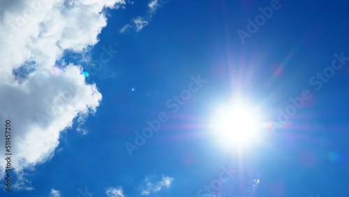 background of white thick cumulus clouds on a blue sky on a sunny bright day © belavinstock