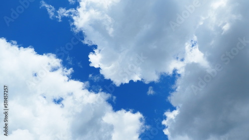 background of white thick cumulus clouds on a blue sky on a sunny bright day