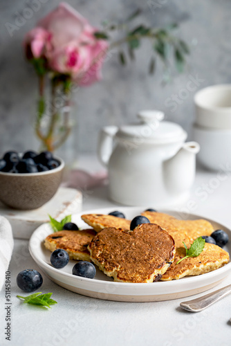 Pancakesheart shaped with fresh blueberries, Morning breakfast, delicious vegan pancakes. Bright background.