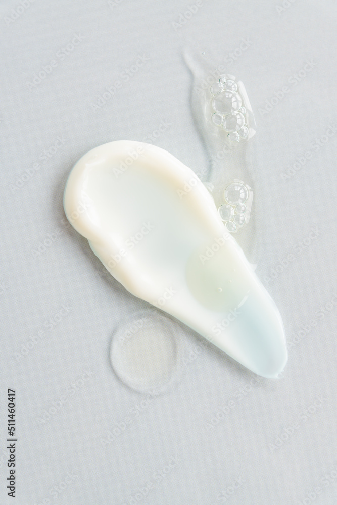 yellow beauty face oil and face cream smear on gray background. Skin care cosmetic advertisement with copy space. yellow beauty face oil and face cream smear on gray background. Skin care cosmetic advertisement with copy space.