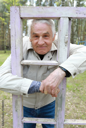 Senior man posing in wooden frame