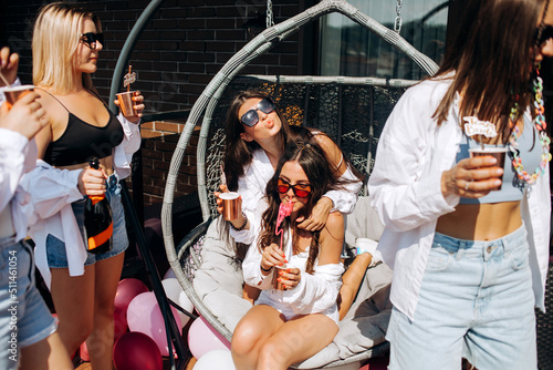 Happy and cheerful group of women friends together dancing and drink champagne on the rooftop at home. Bachelorette party.