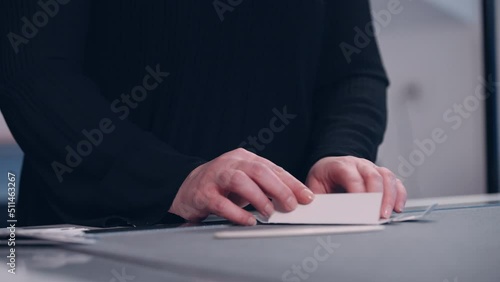 An employee in a factory assembles packaging from cut-out paper.