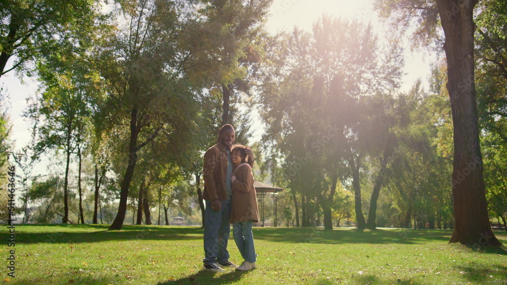 Happy child father standing together on green park field in golden sunlight. Happy child father standing together on green park field in golden sunlight.