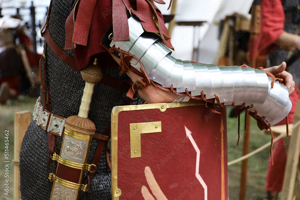 Legionary of Ancient Rome, close up of armor, gladius and scutum of infantry of Roman army on historical reconstruction festival