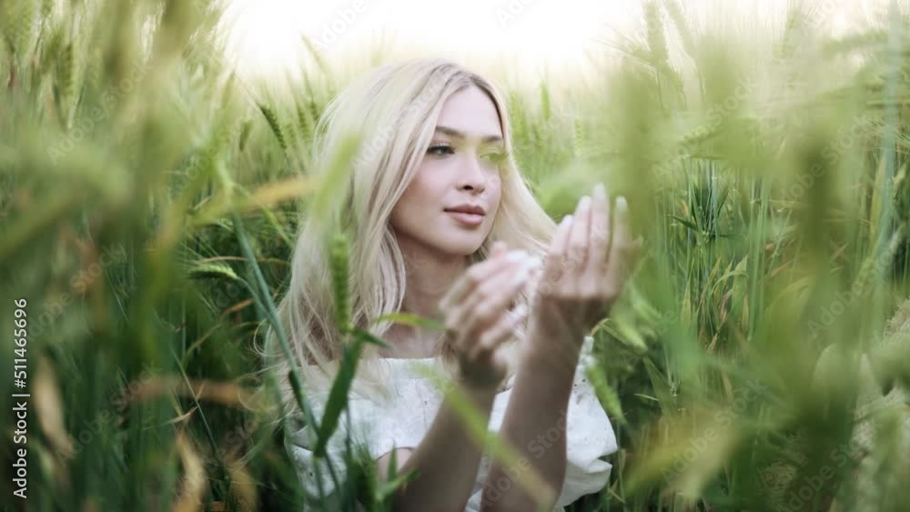 Portrait of gorgeous young woman sitting in green wheat field at the sunset. Concept of freedom. Portrait of gorgeous young woman sitting in green wheat field at the sunset. Concept of freedom.