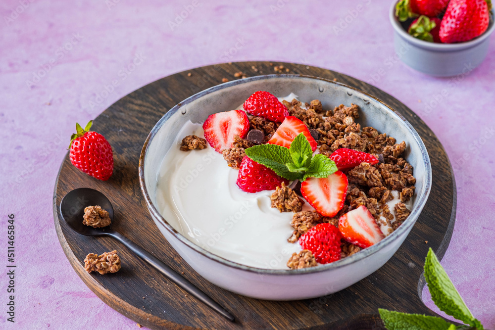 Breakfast, unsweetened yogurt with chocolate baked granola and chopped