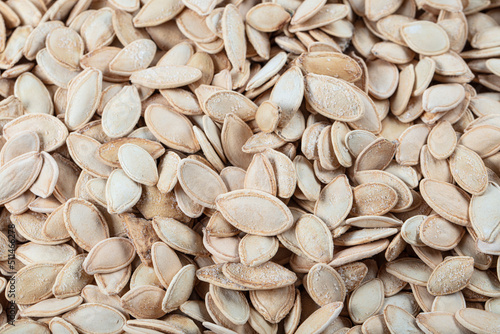 Bowl of raw pumpkin seeds background. Dried pumpkin seeds.