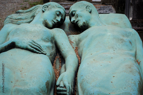 Due amanti di bronzo riposano mano nella mano su una tomba del cimitero monumentale di Milano photo