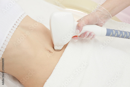 Obraz na plátně beautician removes hair on a smooth female belly with a diode laser