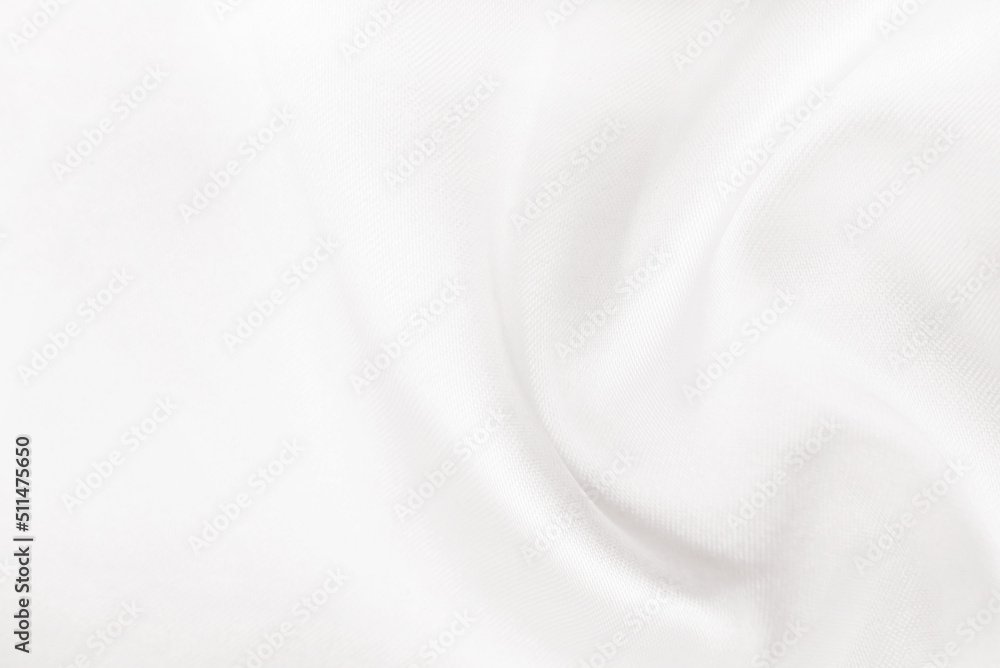 A twisted piece of white fabric. White material or texture with waves and folds. Wrinkled white fabric