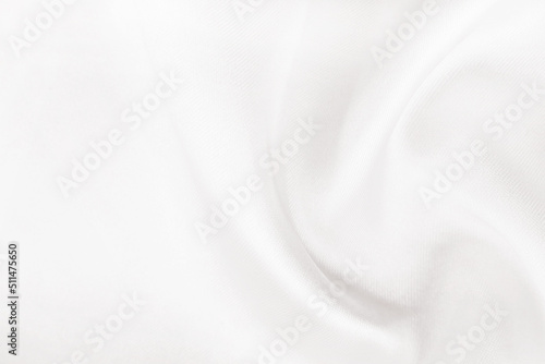 A twisted piece of white fabric. White material or texture with waves and folds. Wrinkled white fabric