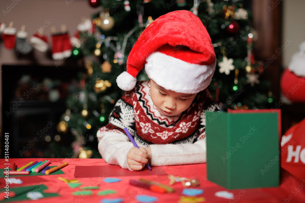 medium shot young girl making Christmas card in front of Christmas tree medium shot young girl making Christmas card in front of Christmas tree