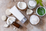 Natural organic cosmetics with coconut butter for body care, spa treatment. Fermented beauty care - coconut oil, bath salt, cosmetic cream, serum and hydrogel eye patches. View from above.