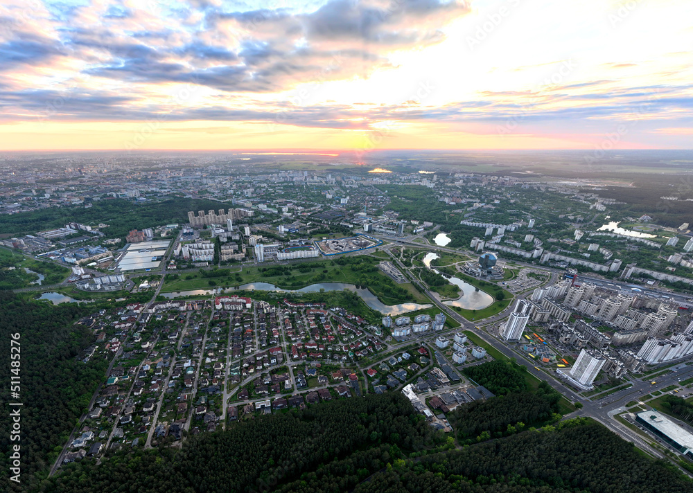River in city on sunset, aerial view. Suburb houses and multi-storey residential buildings near river in Minsk, Belarus. Cottages and wooden suburb house. Suburban house on sunset panarama, drone view
