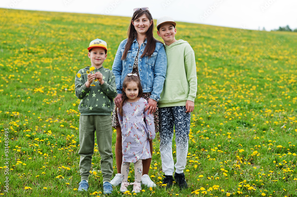 Mother with three kids on a dandelion field. Mother with three kids on a dandelion field.