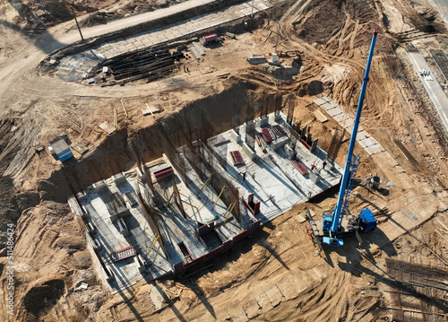 Сonstruction site, aerial view. Monolithic slab foundation and concrete pouring. Mobile auto Crane on formworks. Preparing Formwork for First Floor Slab on building сonstruction. .