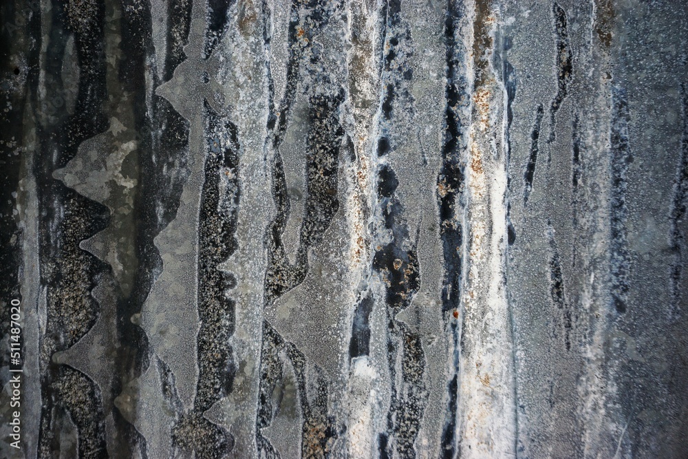 Graue gewölbte Metallfassade mit Rostablagerungen 