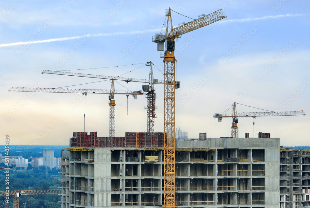 Сonstruction site with tower cranes on building construction. Builder on formworks. Cranes on pouring concrete in formwork. Tower cranes on construction in built environment. Buildings renovation.. Сonstruction site with tower cranes on building construction. Builder on formworks. Cranes on pouring concrete in formwork. Tower cranes on construction in built environment. Buildings renovation..