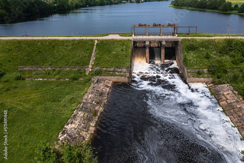 Aerial view of a small old dam on the river in summer