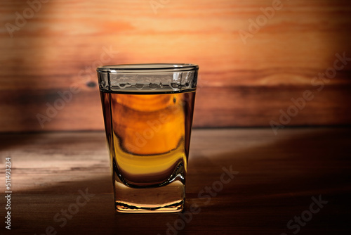 Shot glass on a wooden background close-up