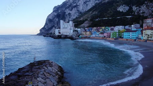 Colored Residential Buildings Of Catalan Bay Revealed Sea Walls In Gibraltar. Aerial Tilt-down Shot