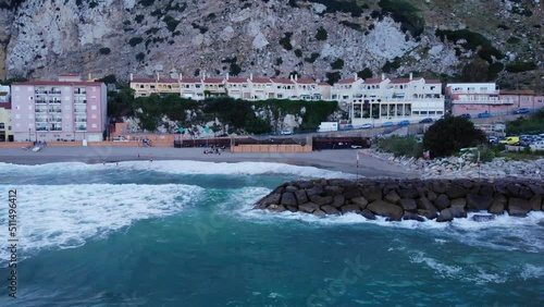 Crashing Waves Onto The Sea Walls At Catalan Bay In Gibraltar.Aerial Sideways Shot