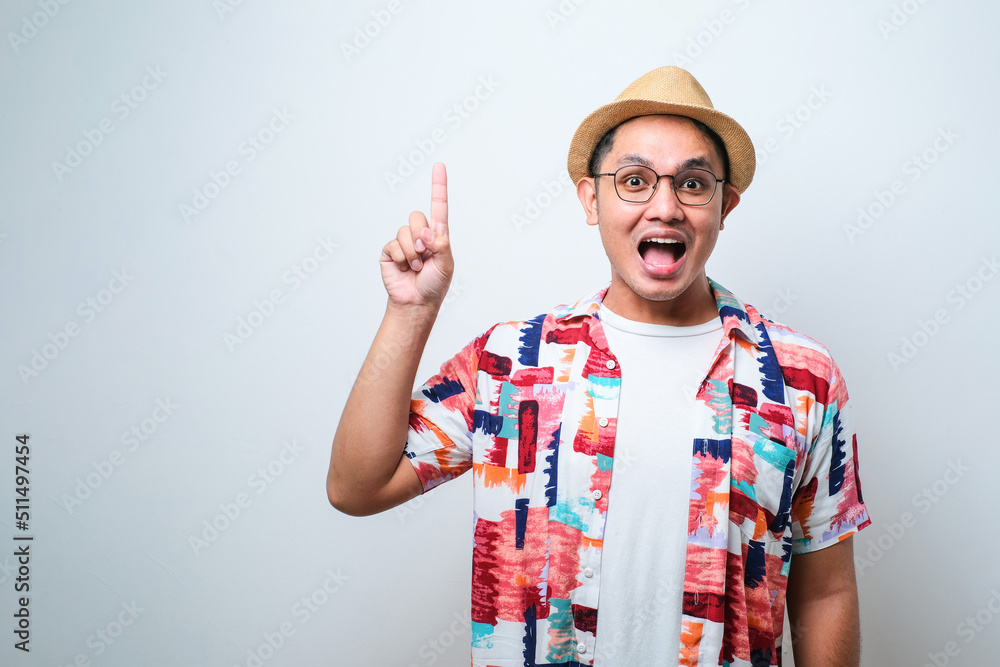 Naklejka premium Asian traveler man intending to realizes the solution while lifting a finger up