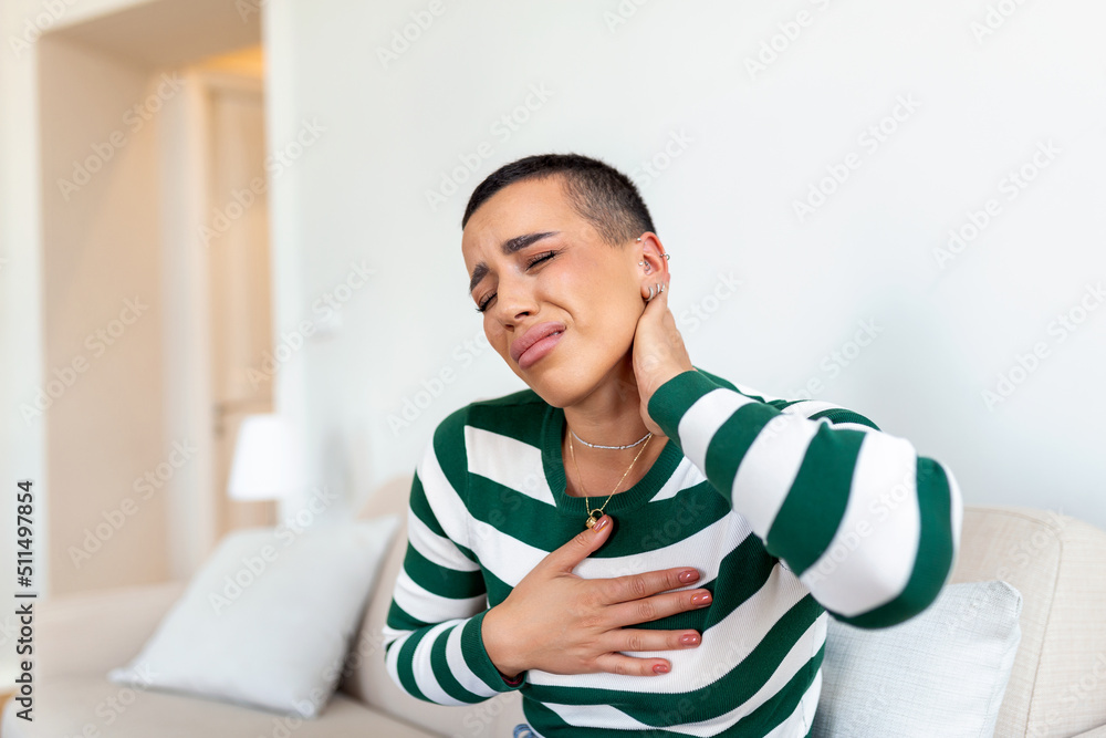 Unhappy young woman suffering from pain in the neck Unhappy young woman suffering from pain in the neck