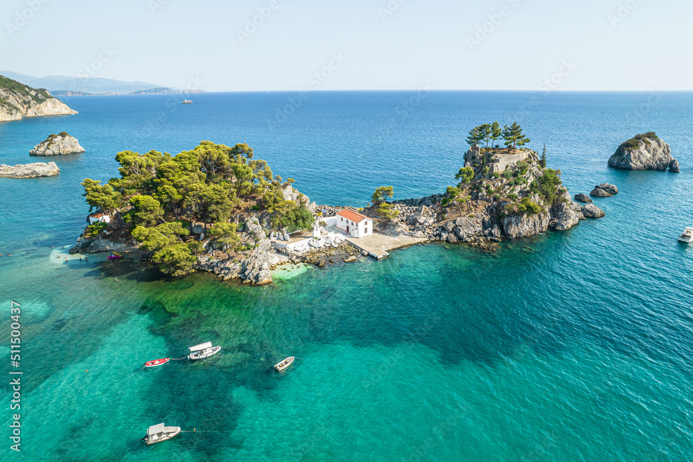The island of Panagia with church located right in front of the port of Parga among in blue, turquoise sea water. Aerial, top, drone view. Greece