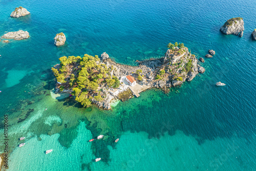 The island of Panagia with church located right in front of the port of Parga among in blue, turquoise sea water. Aerial, top, drone view. Greece