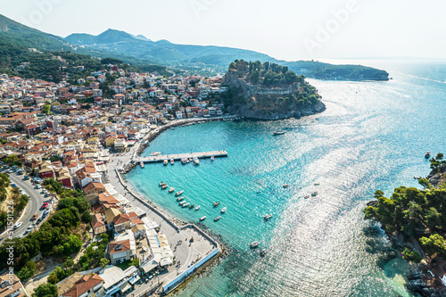 Fototapeta Naklejka Na Ścianę i Meble -  Beautiful colorful houses of seaside town, port of Parga with boats, cruise ship. Sand beach with umbrellas, tourist people, blue, turquoise sea water. Summer vacations and travel concept. Greece