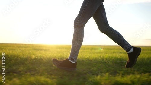 teen girl running legs close up. happy family a kid dream concept. teenage daughter runs barefoot on the grass road in the park field in the summer close-up lifestyle legs. legs run girl concept © ibragimova