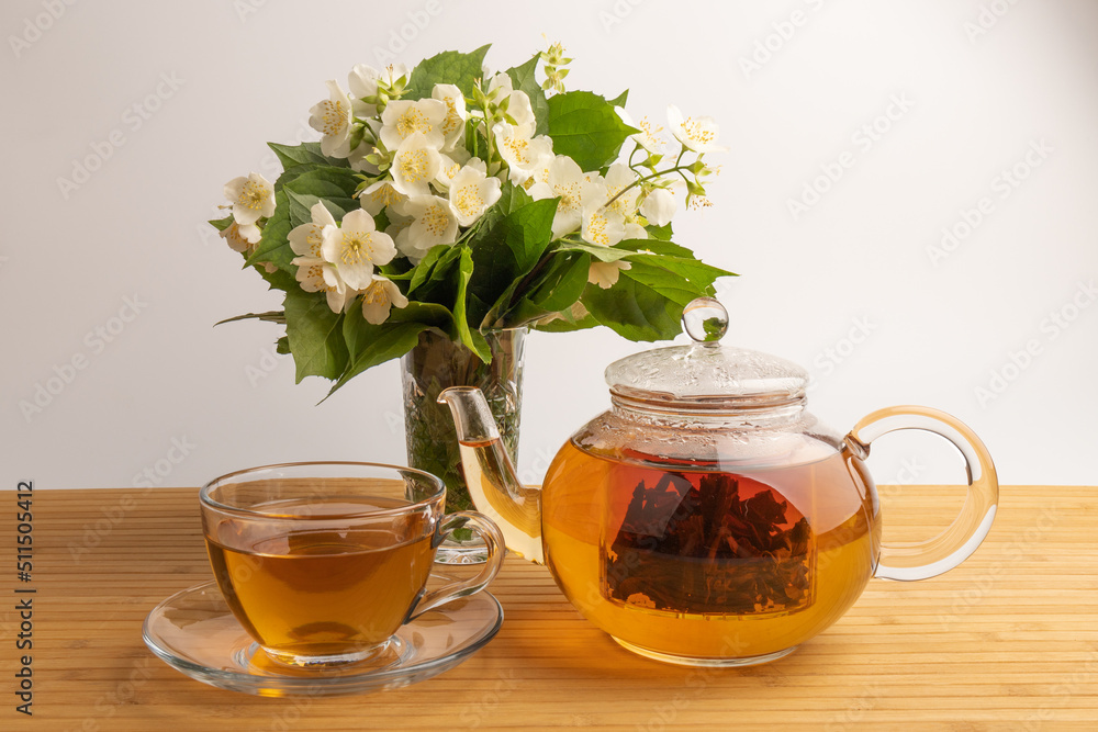 Composition with cup of jasmine tea and flowers on light background Composition with cup of jasmine tea and flowers on light background