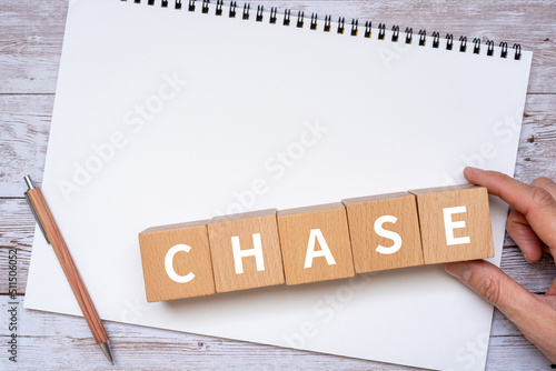 追跡のイメージ｜「CHASE」と書かれたブロック、ノート、ペン、手