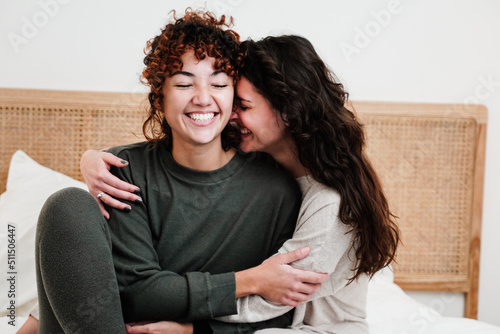Gay female couple surprising lover with engagement ring in bed at home - Lgbt lesbian love and romance concept