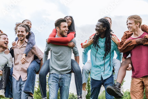 Happy multiracial group of friends having fun outdoor - Summer vacations and friendship lifestyle - Focus on African man face